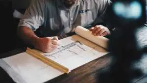 Man looking at a construction plan - keep informed to cope with a neighbor's renovation.